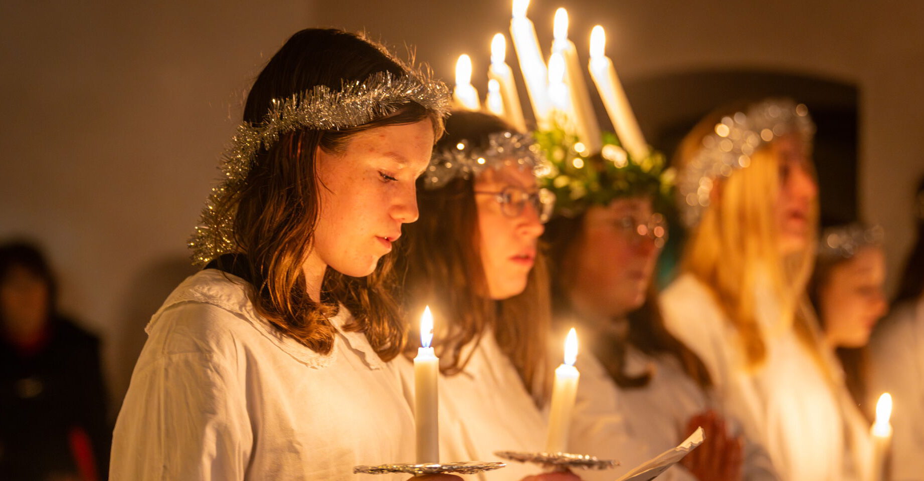 Ein Mädchen beim Luziafest in Rech an der Ahr mit einer Krone aus brennenden Kerzen.